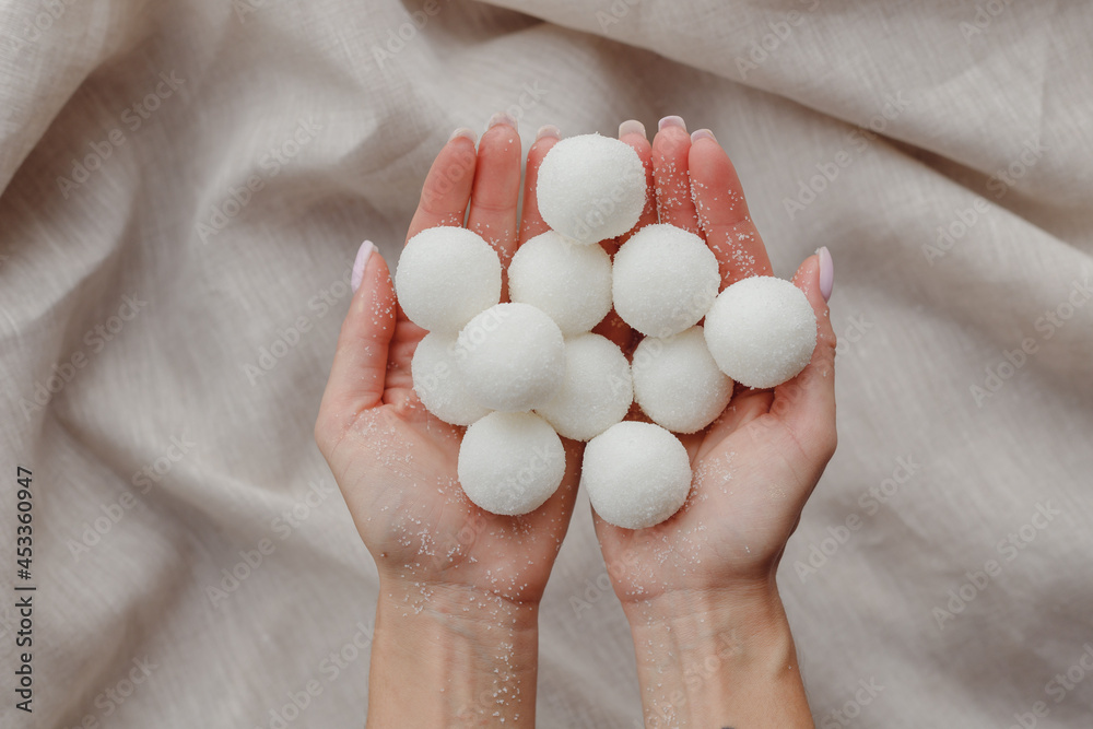 Female hands holding solid handmade natural shampoo or sugar scrub balls