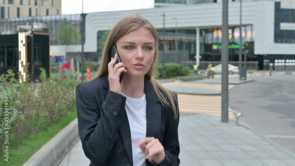 Happy Businesswoman Attending Phone Call while Walking on the Street Happy Businesswoman Attending Phone Call while Walking on the Street