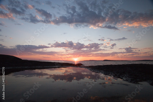 gentle pink sunset over large water and a quiet lake, reflections of scandinavia,