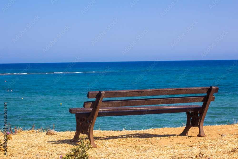 Empty wooden bench by the sea