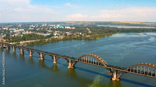Aerial photo - Beautiful city landscape with a river. Photo of a beautiful long bridge over the river from the throne. Urban environment with a wide river.