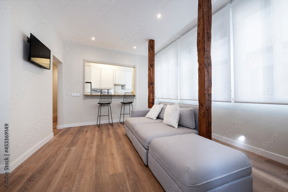 sofa with chaise longue with old wooden pillars and in the background a window to the kitchen in a vacation rental apartment sofa with chaise longue with old wooden pillars and in the background a window to the kitchen in a vacation rental apartment