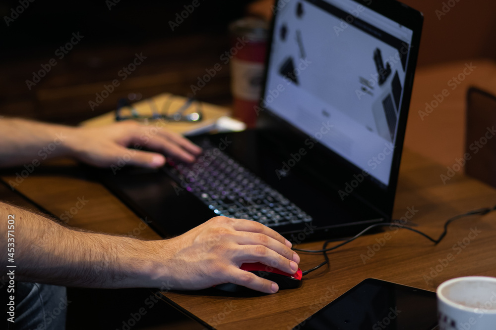 Adult Young Person Typing and Working on a Laptop on the Wood Table Adult Young Person Typing and Working on a Laptop on the Wood Table