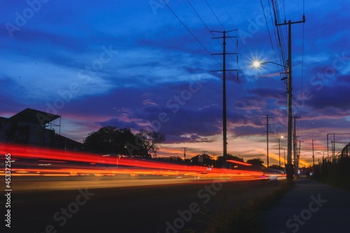 Paisaje urbano con el trafico en forma de haces de luces de fondo  tomada con larga exposici  n con destaques en azul  rojo y naranja 