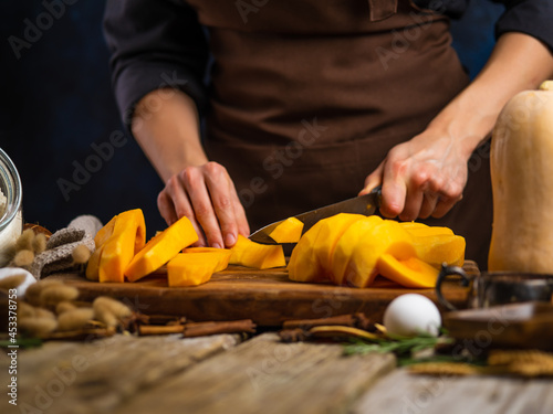 The chef prepares pumpkin filling for a traditional American pumpkin pie. A festive dish. Close-up, wood texture. Step by step recipe. Recipe book, restaurant, hotel.