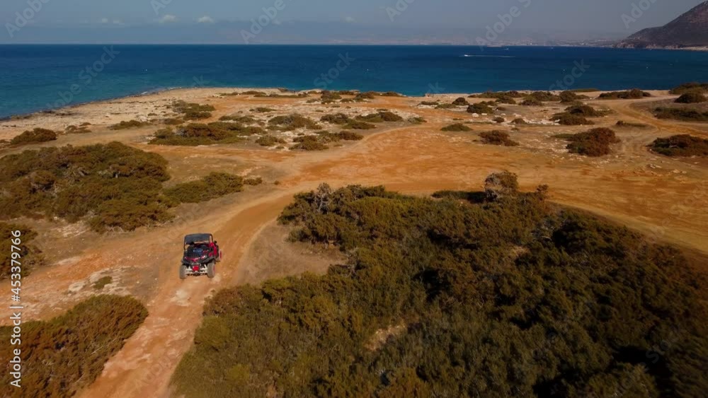 Aerial view of buggy car on the sandy on the sea coast of Cyprus or Greek in summer. Extreme trip off road place. Lovely outdoor adventure for tourists Aerial view of buggy car on the sandy on the sea coast of Cyprus or Greek in summer. Extreme trip off road place. Lovely outdoor adventure for tourists