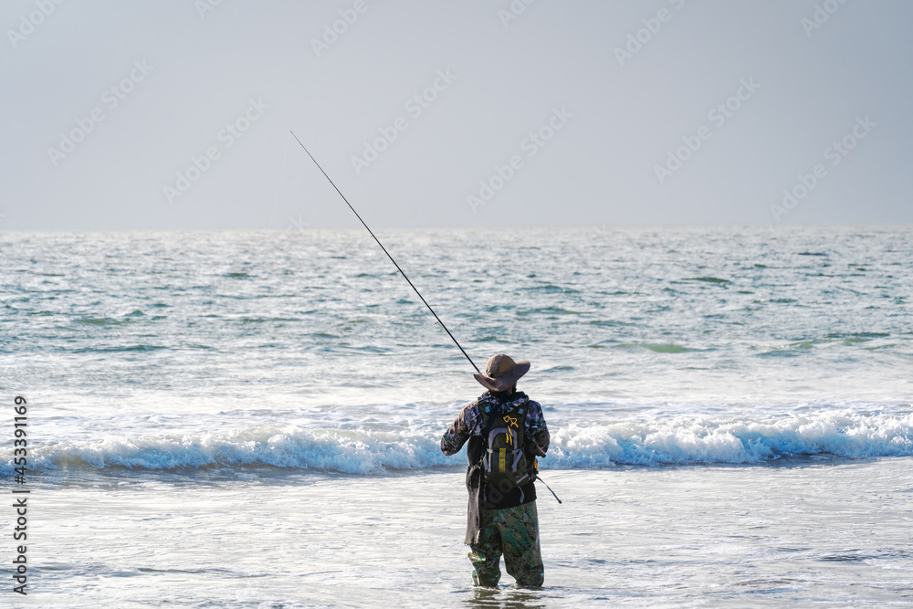 man fishing on the beach alone