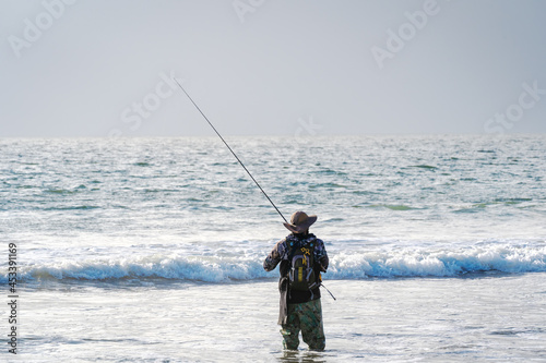 man fishing on the beach alone