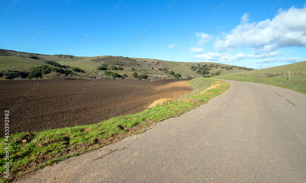 Fototapeta premium Plowed field next to road in Central California near Guadalupe California USA