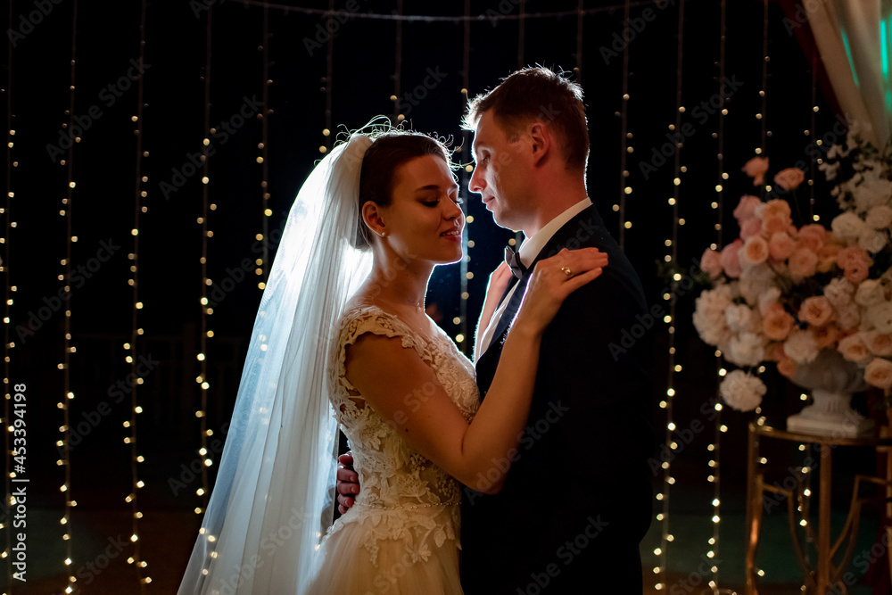 bride and groom at evening wedding ceremony in park among light bulbs bride and groom at evening wedding ceremony in park among light bulbs