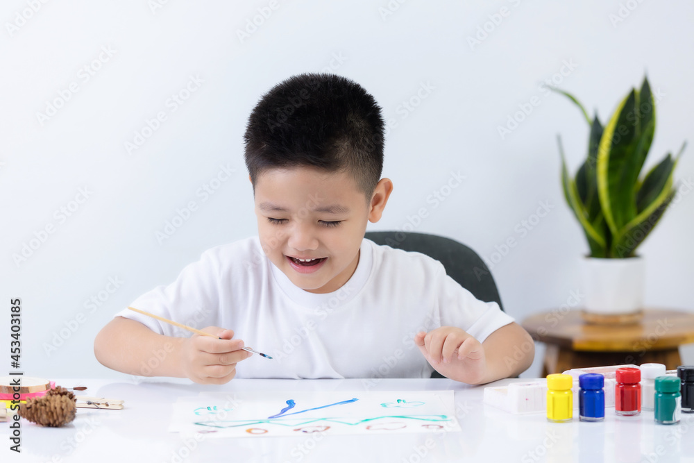 Happy little Asian kid at the table draw with water color Learning and education of kid. Happy little Asian kid at the table draw with water color Learning and education of kid.