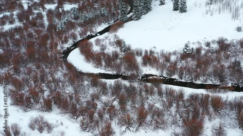 Aerial over snow frosted, winter landscapes.
