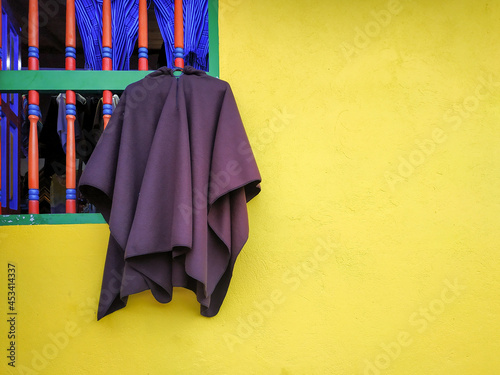 A poncho hanging from a wooden window in guatape, colombia photo