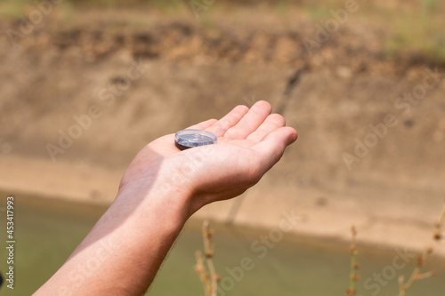 a tourist on the river bank is guided by a compass in his hand © сергей тарануха