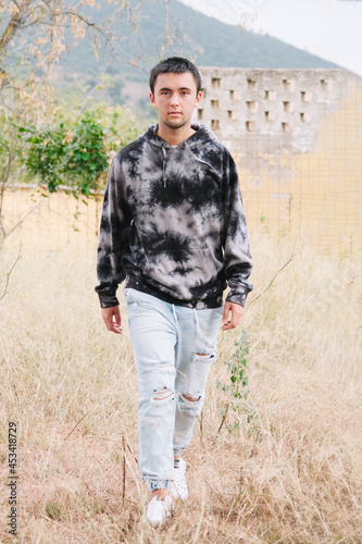 Teenager walking through the field looking at the camera.