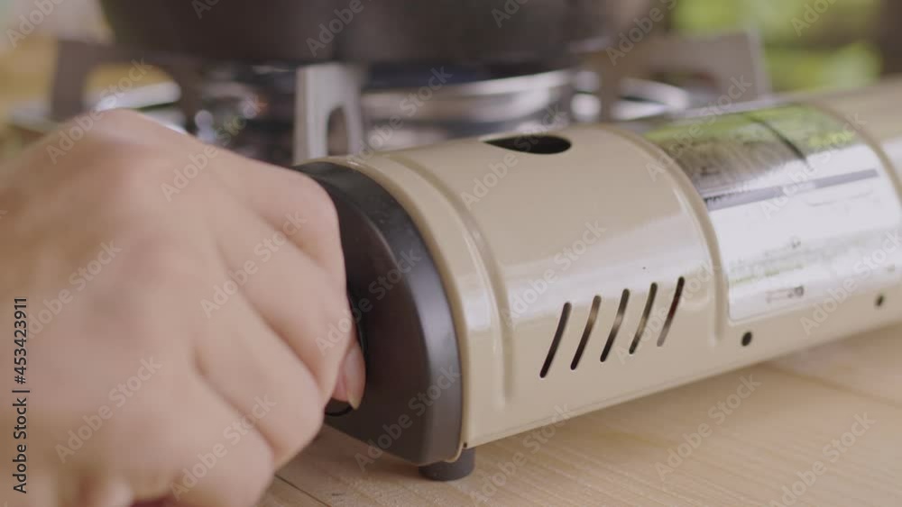 Close up view of hand turn on adjusting the gas stove Close up view of hand turn on adjusting the gas stove