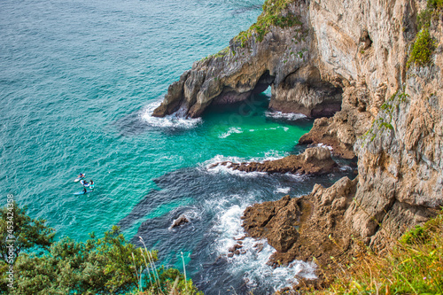 Deporte acuatico y piraguas en hermosa costa rocosa en Santoña, norte de España