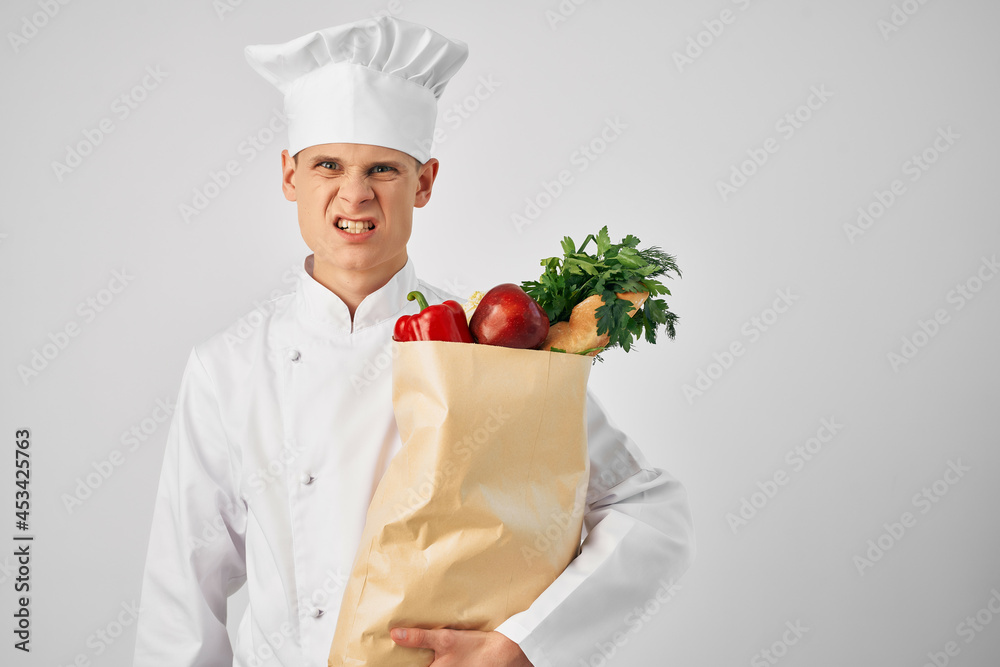 a man in a chef's uniform with a package of groceries delivery of a restaurant service