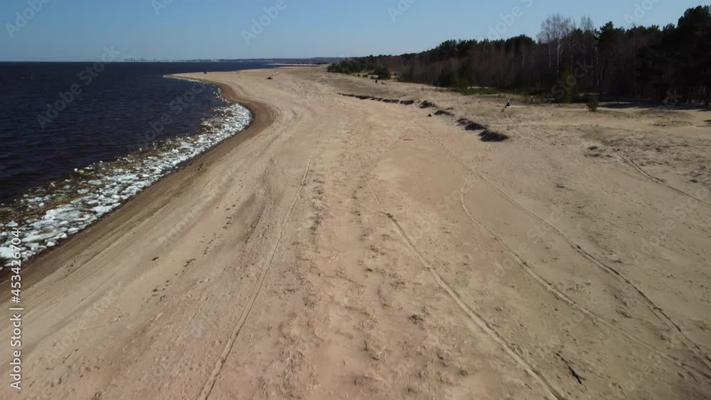 Drone flight over the beach in early spring on a sunny morning. Gulf of Finland beach, St. Petersburg, Russia Drone flight over the beach in early spring on a sunny morning. Gulf of Finland beach, St. Petersburg, Russia