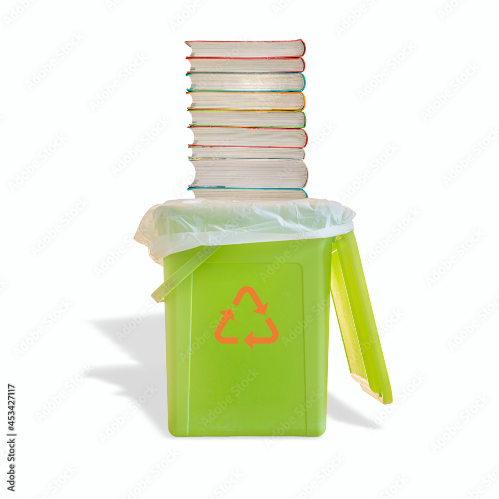 Green garbage trash bin with bag and a pile of paperback books with its