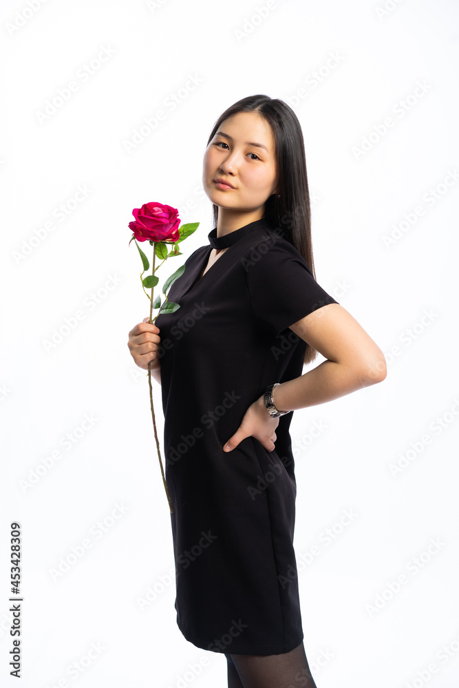 portrait of a girl in a black dress with long black hair on a white background. Oriental beauty with red rose portrait of a girl in a black dress with long black hair on a white background. Oriental beauty with red rose
