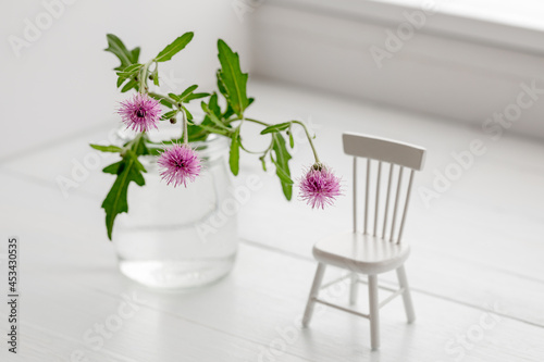 Wildflowers Cotton Thistle in a jar and miniature furniture on the windowsill