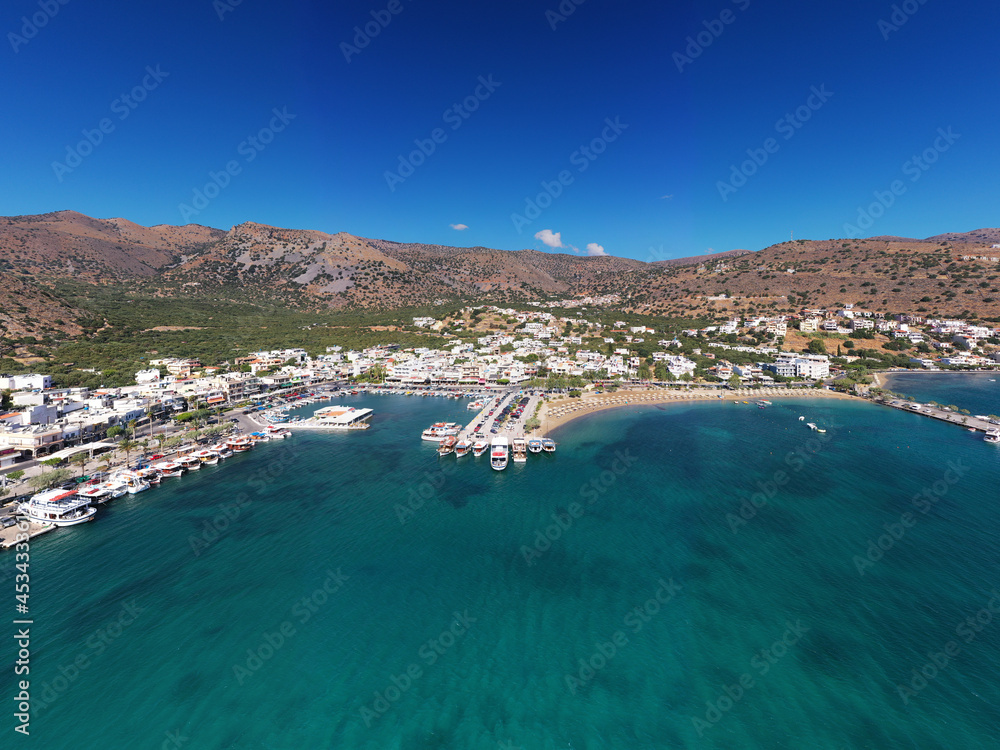 panoramic view of the sea and mountains and ships on turquoise water filmed from a drone