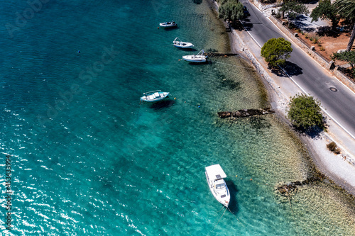 panoramic view of the sea and mountains and a boat on turquoise water filmed from a drone