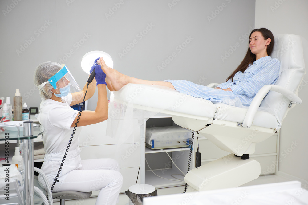 Obraz premium Peeling feet Pedicure SPA procedure in the beauty salon. Electric apparatus for pedicure. Woman getting her feet peeled in spa center