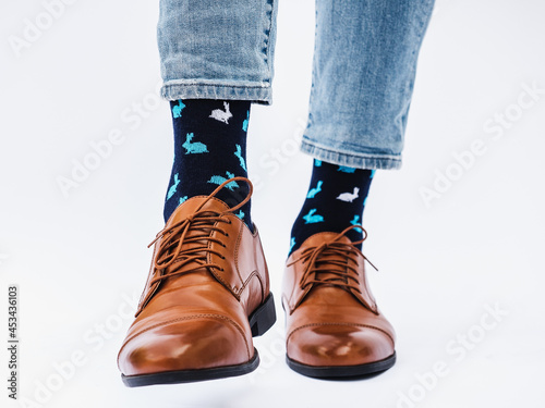 Men's legs, trendy shoes and bright socks. Close-up, indoors. Style, beauty and elegance concept