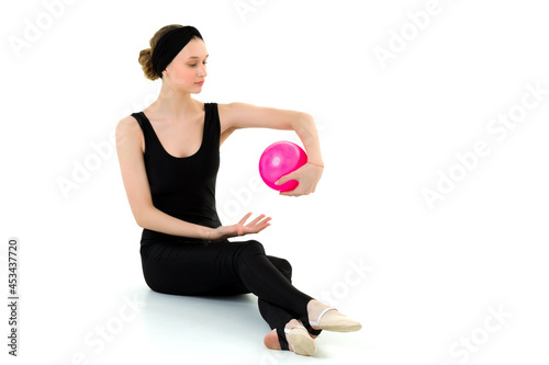 Teen girl doing rhythmic gymnastics with pink ball