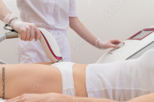 A woman in a professional beauty salon removes unwanted vegetation in the bikini area using laser hair removal