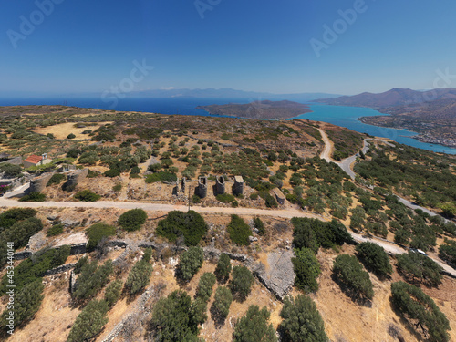 a panoramic view of the ancient centuries-old mills against the backdrop of mountains and olive groves of Crete filmed from a drone 