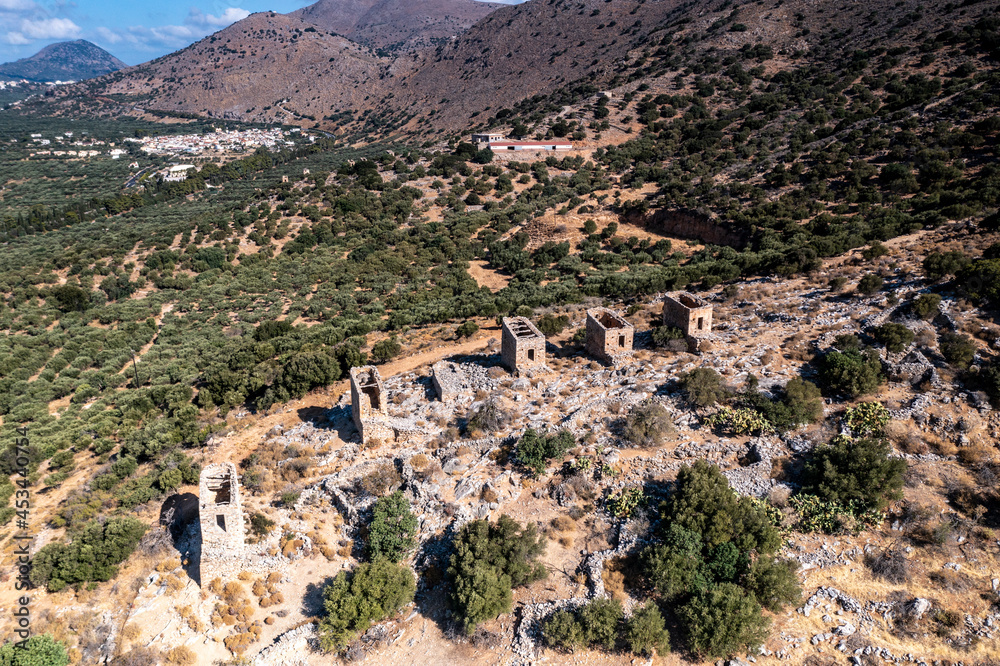 a panoramic view of the ancient centuries-old mills against the backdrop of mountains and olive groves of Crete filmed from a drone 