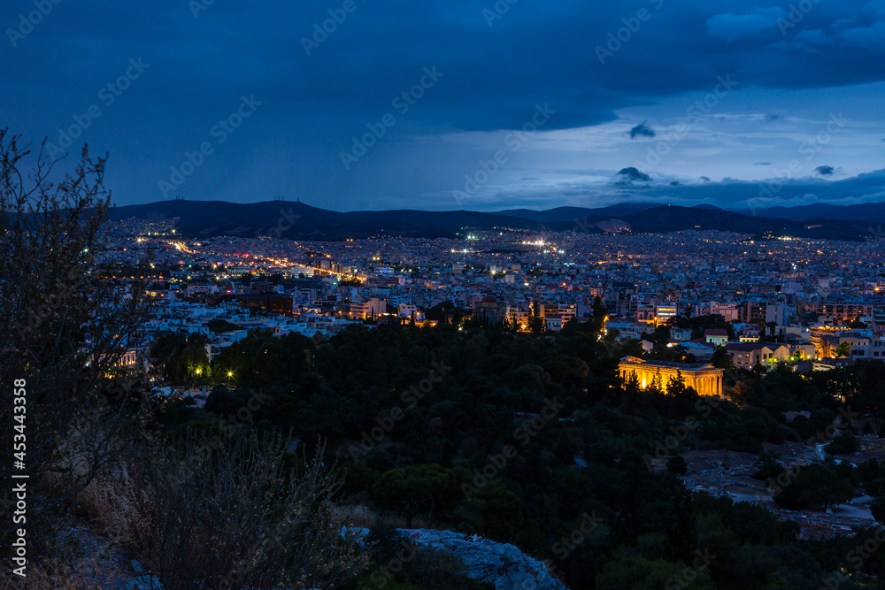 ギリシャ　アテネのアレオパゴスの丘から見える夜景と古代アゴラ内にあるライトアップされたヘパイストス神殿