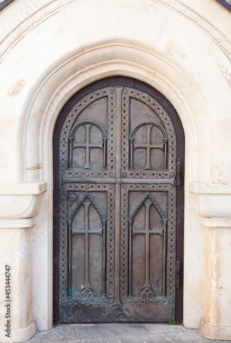 Arched metal doors of the church with carvings. Forged gates of the monastery.