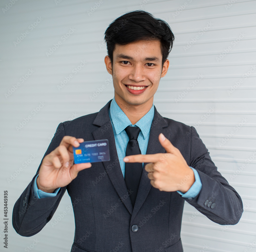 Asian male manager demonstrating credit card Asian male manager demonstrating credit card