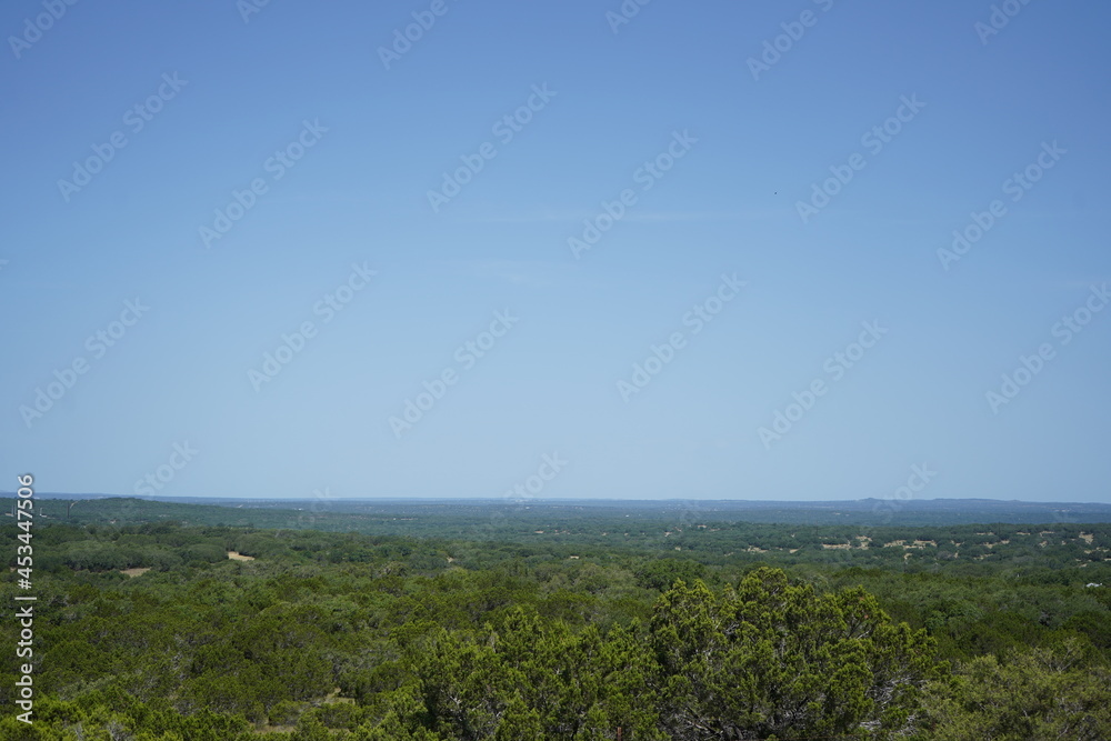 テキサス州ドリッピングスプリングス郊外で見た森と青空