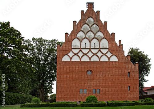 General view and architectural details of the Evangelical Augsburg Church in the village of Wejsuny in Masuria, Poland, built in 1910 in red brick in the neo-Gothic style. photo