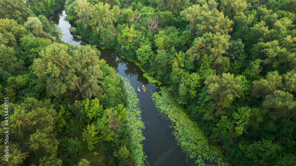 Aerial view of scenic small river with green forested banks. Bobrovnia, a distributary of Desna River is perfect place for calm kayaking, canoeing and SUP boarding within the Kyiv city limits, Ukraine