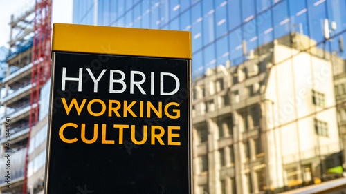 Hybrid Working Culture on a city-center sign in front of a modern office building
