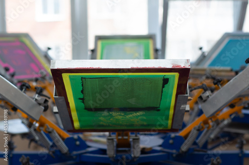 Carousel Frame, squeegee and plastisol color paint Serigraphy silk screen print process at clothes factory