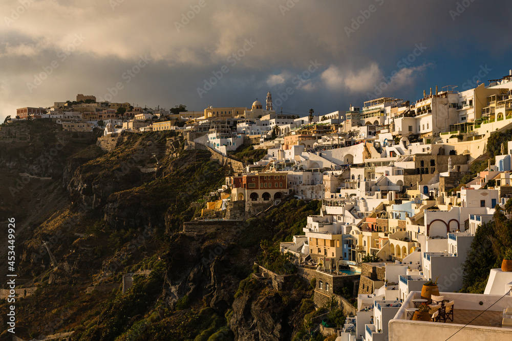 ギリシャ　サントリーニ島の崖の上にある夕陽で照らされたフィラの街並み