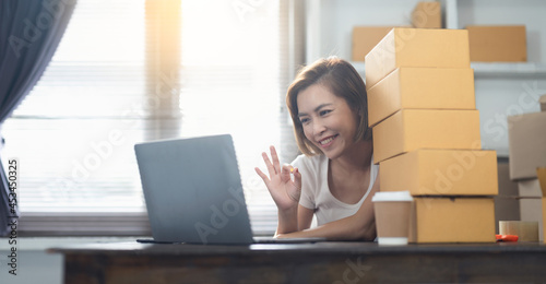 Young Asian women are using laptop to record live chatting with customers, Use sign language Okay means OK, Order confirmation and online sales or sell online.