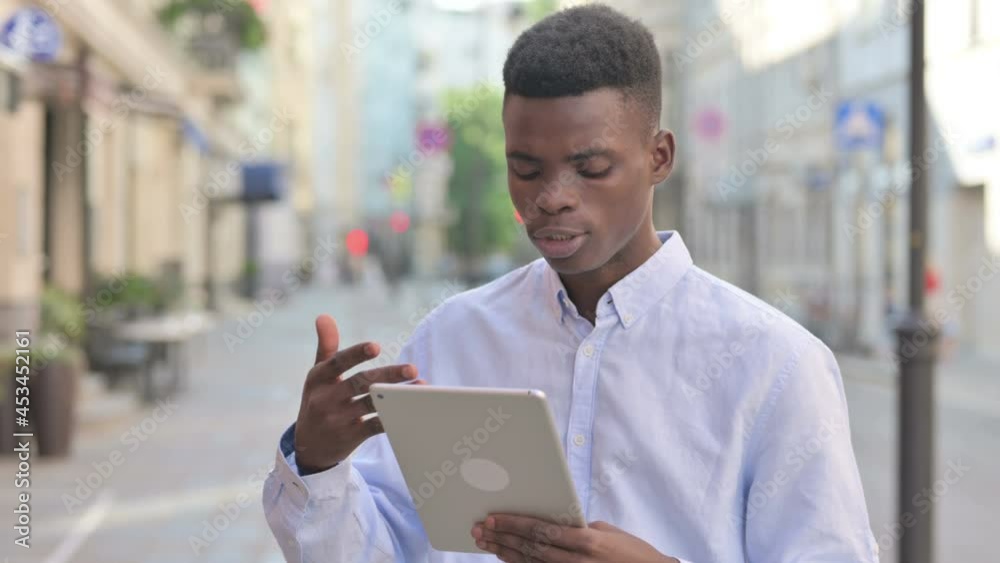 African Man Talking on Video Call on Tablet in Street African Man Talking on Video Call on Tablet in Street