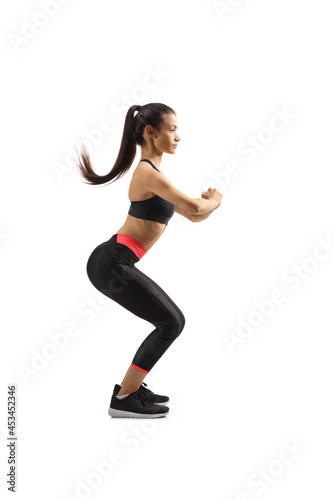 Fototapeta Naklejka Na Ścianę i Meble -  Full length profile shot of a young female in sport clothes exercising