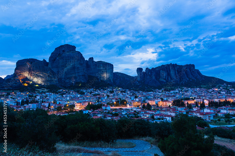 ギリシャ　ライトアップされたカランバカの街並みと後ろに広がるメテオラの奇岩群