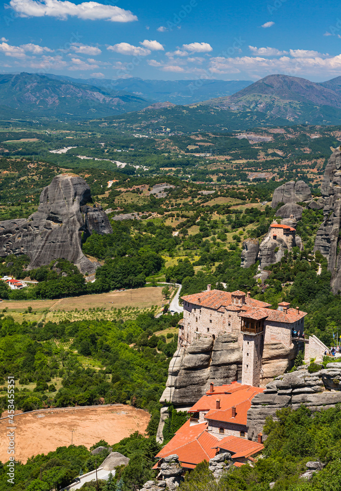 ギリシャ　メテオラの断崖絶壁の岩山の上に建つルサヌ修道院と聖ニコラオス・アナパフサス修道院と後ろに広がる大自然