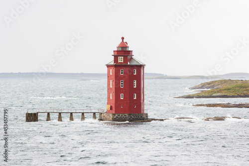 This 17.5-metre tall lighthouse in Norway is made of stone with an octagonal-shaped tower that is painted red photo