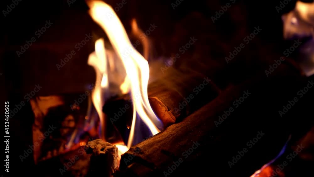 Fire in fireplace. Firewood burning in fireplace for heating at home in winter season. Wooden logs in flame on dark background. Macro shot. Fire in fireplace. Firewood burning in fireplace for heating at home in winter season. Wooden logs in flame on dark background. Macro shot.